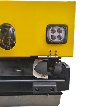 Close-up of a yellow and black machine with a light on a white background