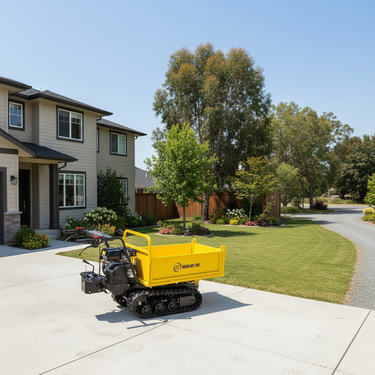 A yellow and black compact tracked loader dump truck parked on a concrete driveway in front of a suburban house with a green lawn and trees.