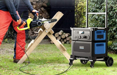 Person using a chainsaw with a portable generator in an outdoor setting