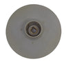 A beige plastic circular disc with a central hole, likely a replacement part, placed on a scratched light gray surface.