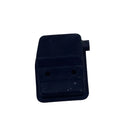 A small black plastic electrical connector or switch component placed on a scratched white surface.