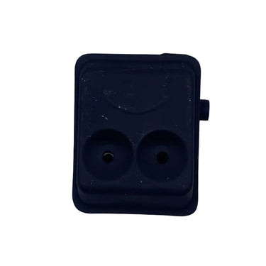 A small black plastic dual-port electrical connector or adapter with two round sockets, placed on a scratched white surface.