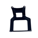A black plastic mounting bracket or frame part, photographed flat on a light gray, scratched surface.