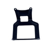 A black plastic mounting bracket or frame part, photographed flat on a light gray, scratched surface.