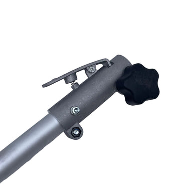 A close-up of a silver metal pole with a black star-shaped adjustment knob and a small metal clip, resting on a scratched white surface.
