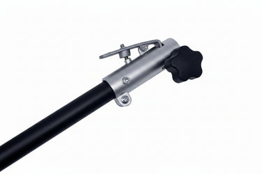 A close-up of a silver metal pole with a black star-shaped adjustment knob and a small metal clip, resting on a scratched white surface.