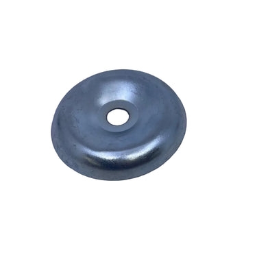 A small circular metallic silver cap or plug with a central hole, resting on a scratched light gray surface.