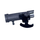 A small metal mechanical component with a black lever, photographed on a scratched light gray surface.