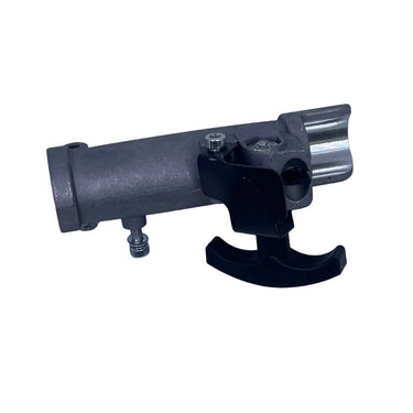 A small metal mechanical component with a black lever, photographed on a scratched light gray surface.