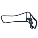 A black metal bicycle frame rack or storage bracket placed inside a white light box or photography backdrop, with a cluttered workshop or storage area visible underneath.