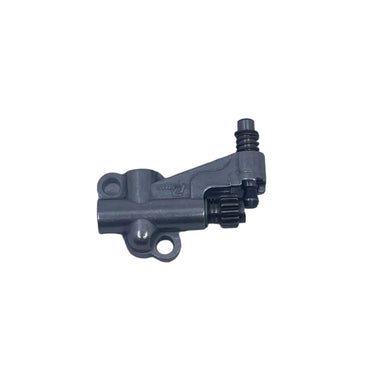 A small metallic gray mechanical part, possibly a sensor or valve, placed on a scratched light gray surface.