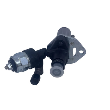 A used automotive fuel injector assembly with a black plastic body, silver metal mounting bracket, and silver metal fuel rail, photographed on a scratched white surface.