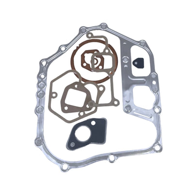 A set of metal engine gaskets and seals arranged on a plain white background, including a large silver outer gasket, brown circular gaskets, a dark gray rectangular piece, and a small black circular piece.