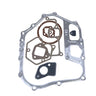 A set of metal engine gaskets and seals arranged on a plain white background, including a large silver outer gasket, brown circular gaskets, a dark gray rectangular piece, and a small black circular piece.