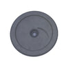 A round gray plastic or rubber disc with a central hole and a small curved marking, photographed from above on a scratched light gray surface.