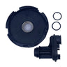 A black circular plastic housing component with a central metal ring, shown alongside a black plastic mechanical fitting and two small black O-rings on a light gray scratched surface.
