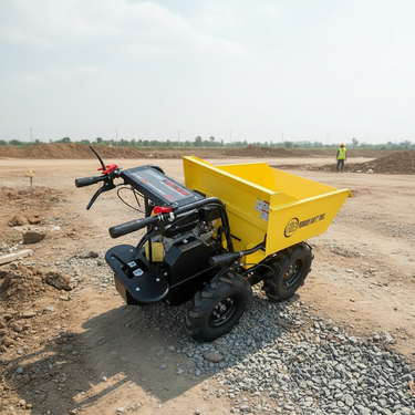 A yellow and black mini dump truck with a rear hopper, photographed outdoors on a dirt construction site under a pale sky. A small worker is visible in the distant background.