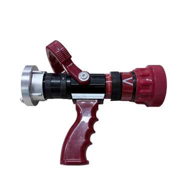 A fire hose nozzle with a red handle and red end caps, a black central body, and a silver metal front collar, placed on a light wood-grained surface.