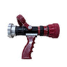 A fire hose nozzle with a red handle and red end caps, a black central body, and a silver metal front collar, placed on a light wood-grained surface.