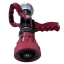 A red and black fire hose nozzle with a red loop handle, resting on a light wood-grained tabletop.