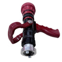 A red and black fire hydrant nozzle with a red loop handle, resting on a light wood-grained surface.